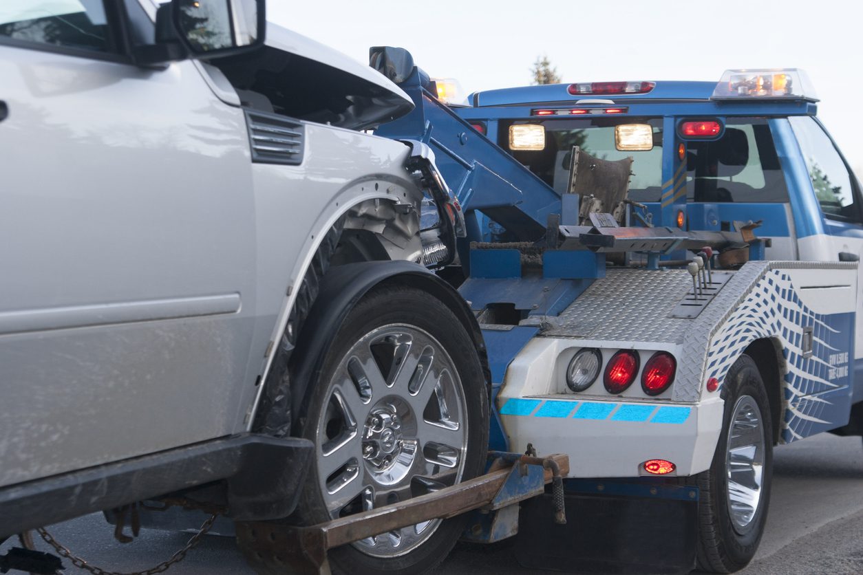 A damaged new vehicle on a tow truck after getting tow truck financing.