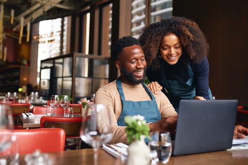 Small business owners using laptop to apply for a restaurant loan