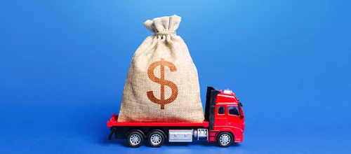The truck is carrying a huge dollar money bag trucking business revenue