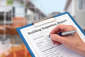 Building Inspector completing an inspection form on clipboard