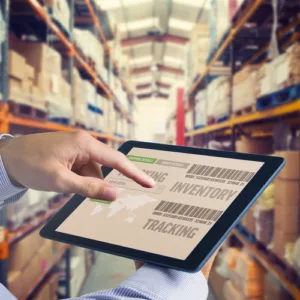 Man using tablet pc against shelves with boxes in warehouse asset inventory