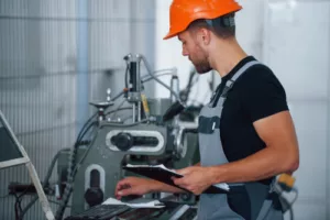 Industrial worker indoors in factory doing planned maintenance